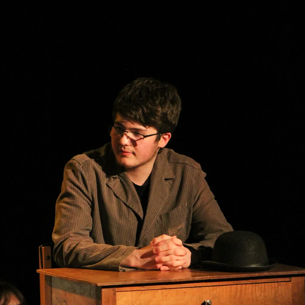 Photo de Kéwan Bernier, sur un bureau (extrait d'une piece de théâtre)
